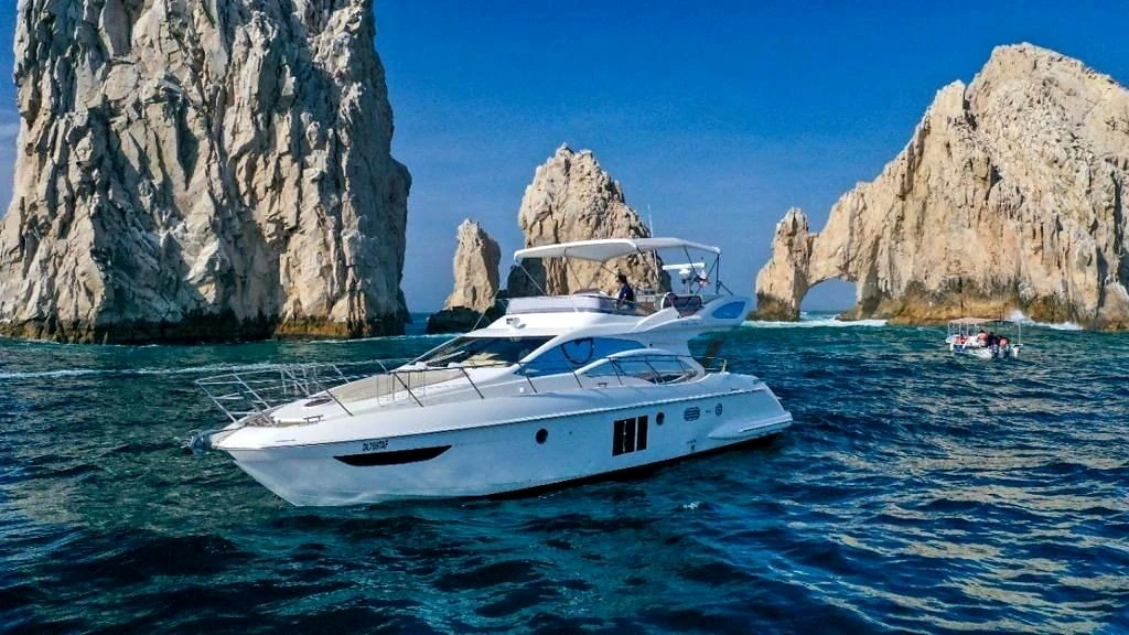 Yate de motor junto a islas rocosas