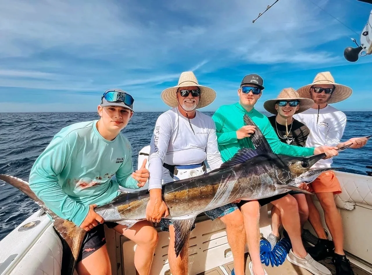Pescadores sosteniendo peces en una embarcación
