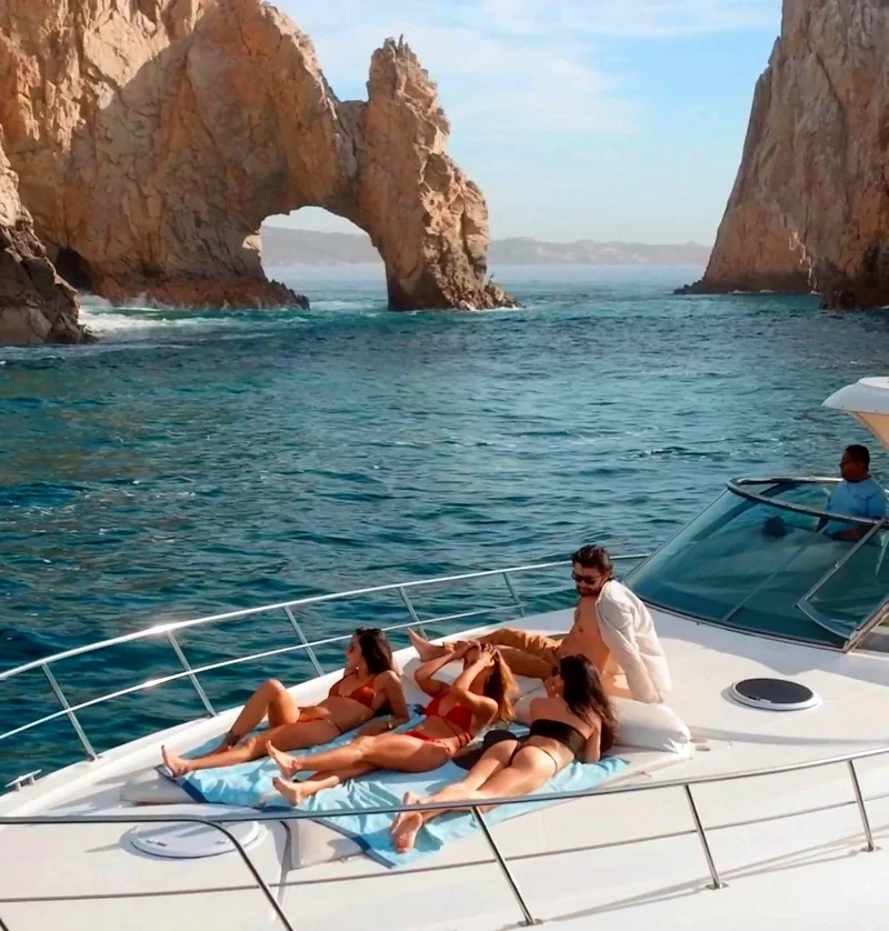 Yacht guests relaxing near Cabo's rock arch Yacht guests relaxing near Cabo's rock arch