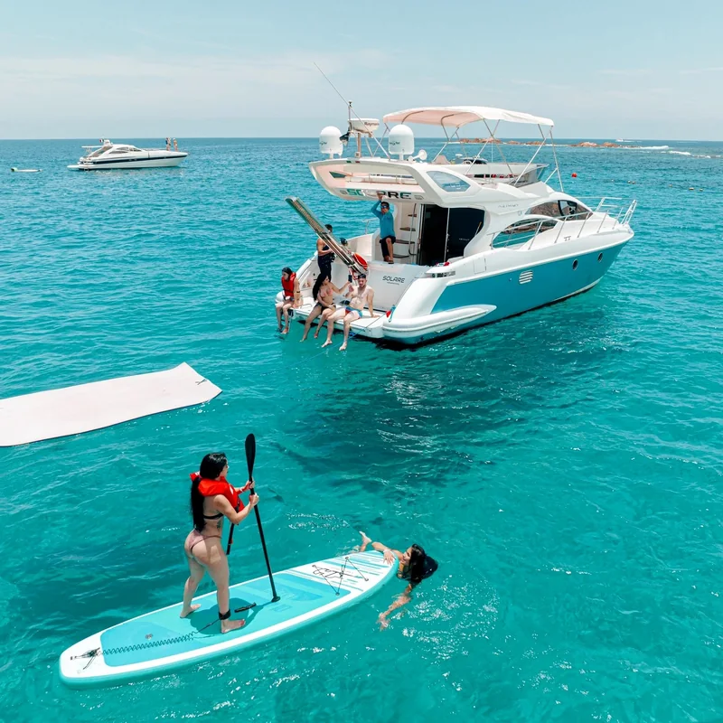 Yacht and paddleboarders in turquoise water Yacht and paddleboarders in turquoise water